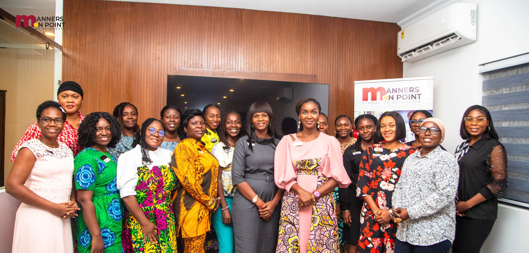 Participants of The Refined Lady standing together with their trainer at the Manners on Point studio.