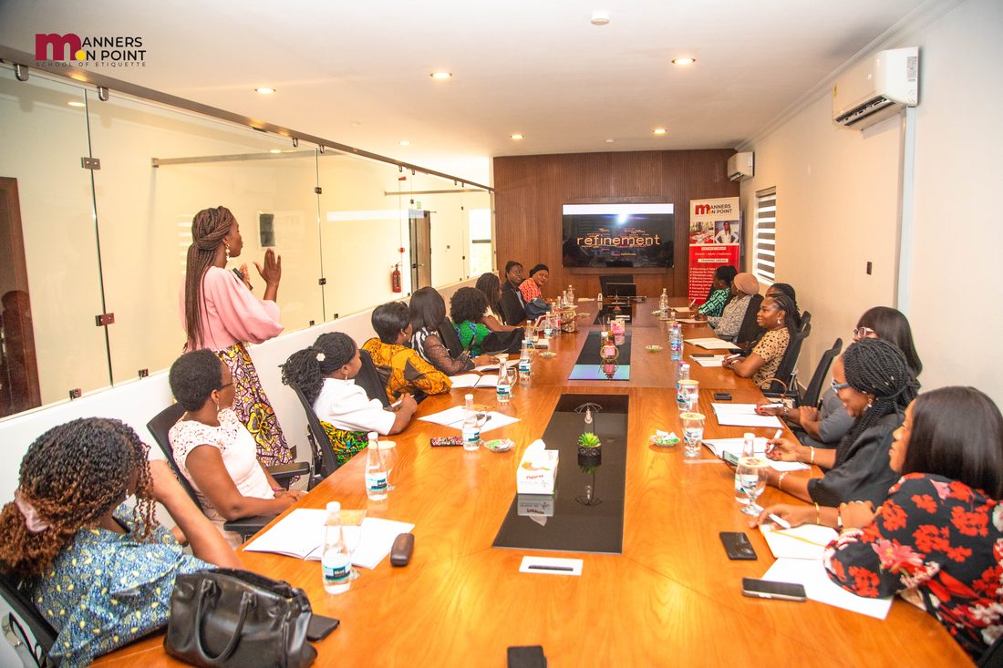 Participants seated around the boardroom table as the trainer leads a session on refinement.